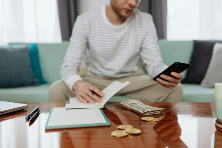 “Flat lay of wallet, coins, and budgeting notes on a wooden desk, representing student pocket money management.”